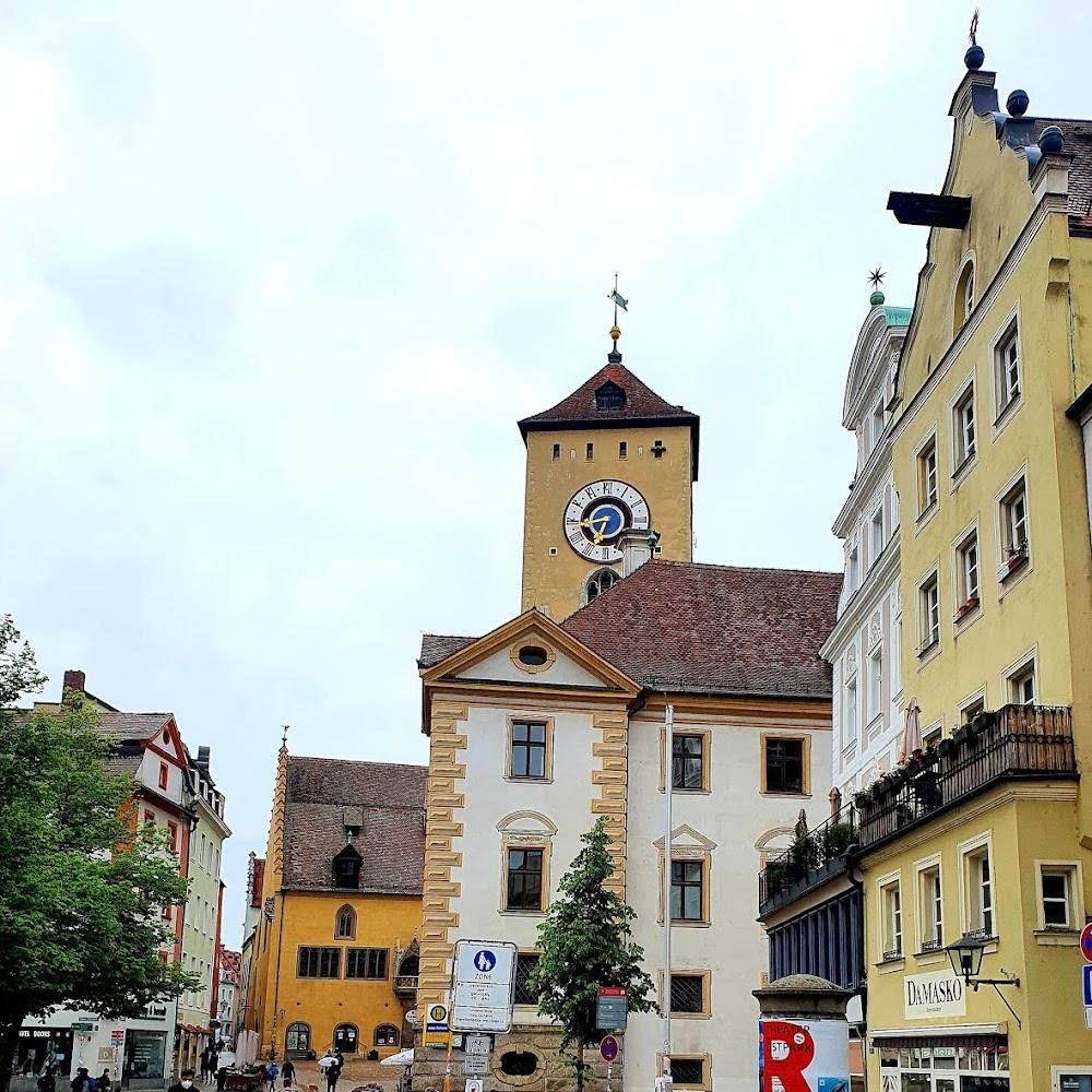 A clock tower and yellow buildings in Füssen.